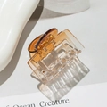 Macro detail of amber gradient square hair claw clip on minimalist magazine background - Square Gold