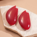Detailed view of red geometric resin earrings on a natural stone base - Red