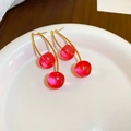 Dettaglio di orecchini a ciliegia con perle rosse trasparenti e ganci dorati eleganti - Ciliegia rosa