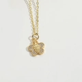 Detailed shot of golden flower pendant necklace with crystals and religious engraving - Flower Shape