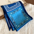 Detail of blue paisley fabric scarf necklace with ethnic patterns on textured backdrop - Necklace-Blue