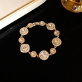 Elegant gold vintage geometric bracelet featuring sparkling crystal pavé on black background - Gold-White
