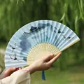 Elegant Chinese folding fan with blue crane landscape art and a silk tassel accessory - Cranes from All Directions Light Handle