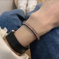 Classic beige checkered bangle worn on wrist with black smartwatch in lifestyle setting - Checked Single Strand