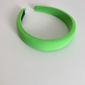 Detailed macro view of a fluorescent green sponge headband with smooth satin texture - Green