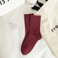 Deep red ribbed crew socks made of combed cotton, displayed on a minimalist beige fabric - One Size / Ancorra Red
