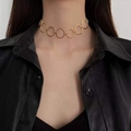 Detailed close-up of a high-polish gold choker necklace with linked circular geometric rings - Gold