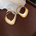 Dettaglio ravvicinato di orecchini geometrici dorati su fondo in pelle marrone - Oro (Perno in argento sterling 925)