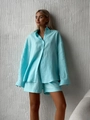 Detailed texture of light blue linen shirt and shorts set with loose fit on a model - Lake Blue