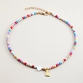 Detail of colorful beaded necklace with white heart charm and gold initial L pendant - Letter L