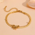 Détail de la chevillère dorée à double rang avec nœud papillon et chaîne serpent - Bracelet Noeud Double Couche Or