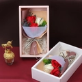 Detail of handmade soap rose gift boxes in pink and white with decorative mesh and ribbons - Red