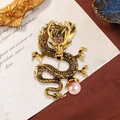 Vintage gold dragon brooch with shimmering crystals and a soft pink pearl accent - Champagne