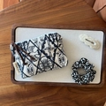 Detailed flat lay of handmade cotton linen embroidery pouch with leopard hair accessories - Beige