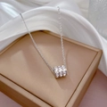 Dettaglio collana a cilindro in argento con zirconi su una confezione regalo in seta - Argento