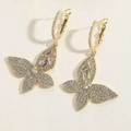 Detail of golden butterfly earrings featuring clear rhinestones on beige background - Butterfly Style (ES2407-7)