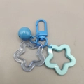 Detail of blue acrylic star keychain featuring a painted bell and transparent star pendant - Blue