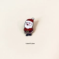 Détail d'une broche en émail Père Noël avec dimensions précises de 1,6 cm x 3,2 cm - Père Noël debout