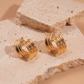 Detailansicht goldener, dreilagiger C-förmiger geometrischer Ohrringe auf Naturstein - Gold / Gold
