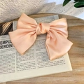 Detail view of a light pink satin bow hair clip on a vintage newspaper background - Spring Clips / Light Pink
