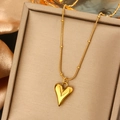 Polished gold heart pendant on beaded snake chain necklace displayed on silk fabric - Polished Heart Snake Chain