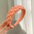 Detailed macro view of vibrant coral orange hand-woven satin headband for women - Watermelon red