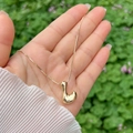 Polished 18K gold-plated bubble pendant on a sleek snake chain held in hand - Gold L