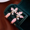 Detail-Makroansicht der Vintage-Schmetterlings-Ohrringe mit Emaille und Perlenbesatz - Silbernadel - Rosa Schmetterlings-Blumen-Ohrhänger