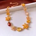 Dettaglio della collana con ciondolo a fiore vintage con cristalli ambra e catena oro - Oro-Giallo-Marrone
