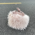 Close-up of pink faux fur bucket bag featuring a leather drawstring on asphalt - Sakura Pink