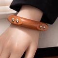 Detail van retro houten brede armband met zilveren metalen klinknagels - Stijl L365 Acht Studs