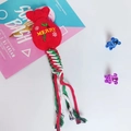 Detail van kersthondenspeeltje met pluchen geschenktas en kleurrijke gevlochten katoenen touw - Kerstcadeauzak