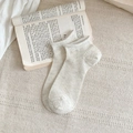 Minimalistische beige ademende katoenen sokken met verticale ribtextuur op een boek - Eén maat / Lichtgrijs