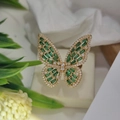 Dettaglio macro dell'anello a farfalla di lusso con pietre verdi e ali dorate eleganti - Oro Zirconia Verde