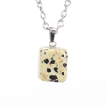 Macro shot of rectangular dalmatian jasper pendant with silver chain on white background - Silver Dalmatian Jasper