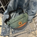 Riñonera de nailon verde y naranja con correa ajustable dentro de un carrito de compra - Verde