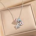 Enamel unicorn and donut pendant necklace displayed in a gold luxury jewelry box - Silver Unicorn Ring Necklace
