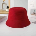 Close-up of a red cotton bucket hat with fine embroidery on a minimalist white desk - M / Small Brim / Red