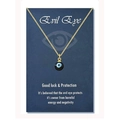 Detailed view of the Evil Eye charm necklace on a blue blessing card with golden chain - 18K Gold Black Bead (Black-Blue Eye)