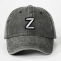Close-up of white embroidered letter Z on washed dark gray cotton baseball cap - Letter Z