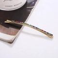 Detail of a gold rhinestone hair clip with multi-colored crystals on a clean background - Colorful