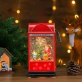 Detail of red vintage Christmas gas station lantern with glowing snow globe and Santa scenery - Gas Pump Santa and Child