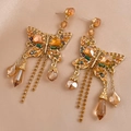 Detailed view of vintage butterfly tassel earrings with crystals and amber stones on silk - Gold Butterfly Tassel Earrings