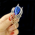 Elegant gold feather brooch with a large teardrop blue crystal and small rhinestones - Blue Waterdrop Crystal