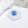 Detail of soft sky blue faux mink fur pom-poms on a white marble display for DIY crafts - Blue
