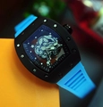 Hollow-out tonneau watch with black case and vibrant blue rubber strap on orange background - Black Case Light Blue Strap
