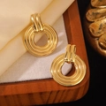 Golden multi-layered circular hoop earrings on a vintage wooden jewelry display - Gold Circular Multi-Loop Vintage Earrings