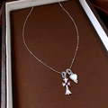 Dettaglio del ciondolo a croce in argento con gemma rossa e collana con cuore in madreperla - Argento