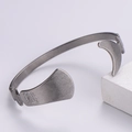 Dettaglio ravvicinato del bracciale rigido argento irregolare con trama in metallo spazzolato - Color Acciaio