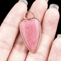 Pink heart-shaped stone pendant with gold-plated edges and metal loop for jewelry DIY - Rhodonite